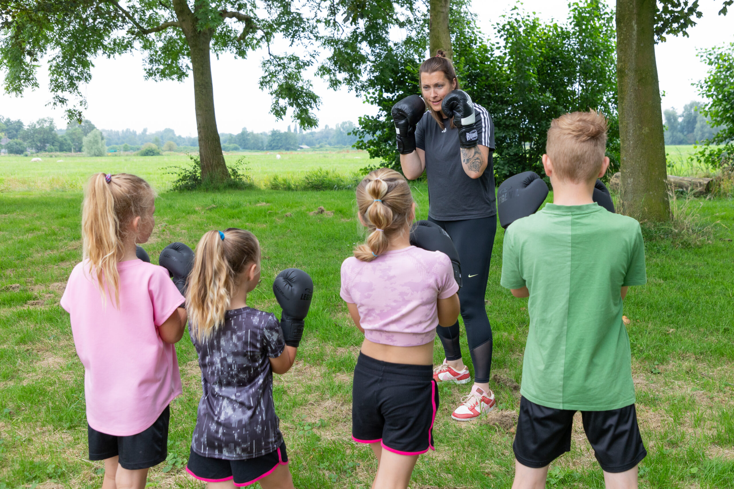 je ziet kinderen die deelnemen aan de weerbaarheidstraining